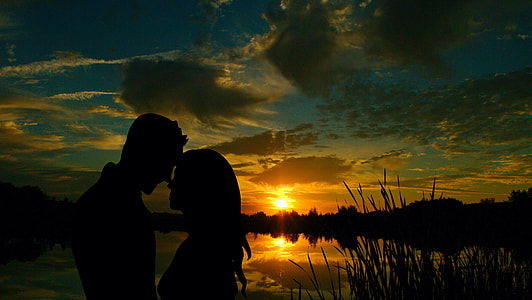 silhouette photography of man and woman beside body of water thumbnail