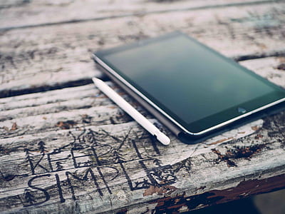 black iPad beside white stylus pen thumbnail
