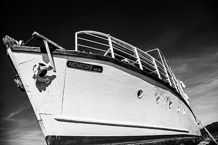 grayscale photo of cruise ship near mountain thumbnail