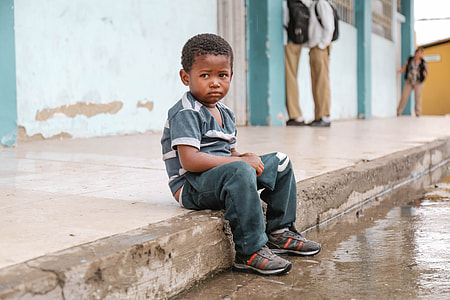 boy sitting on concrete curb at daytime thumbnail