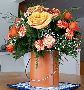 bouquet of orange and yellow petaled flowers in orange bucket thumbnail