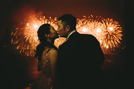 woman kissing woman with fireworks background thumbnail