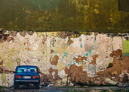 blue sedan parked near brown wall at daytime thumbnail