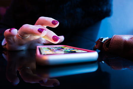 person tapping iPhone screen on black tinted glass surface thumbnail