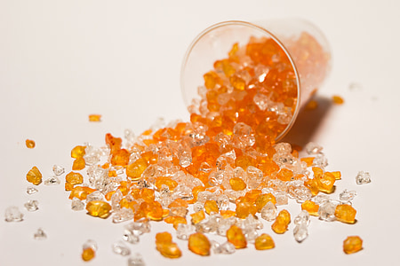 brown and clear gemstones beside clear glass bottle thumbnail