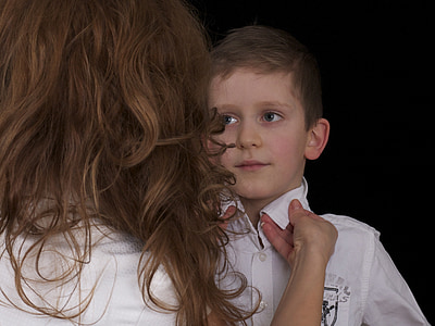 boy wearing white collared shirt standing near woman wearing white shirt thumbnail