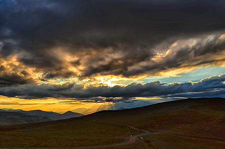 brown field under blue and yellow sky thumbnail