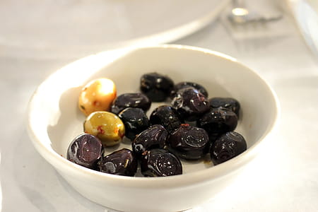 Bowl of black olives on a white table background thumbnail