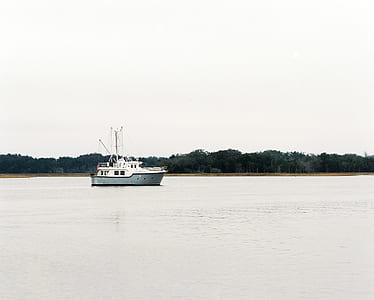 white boat in the middle of body of water thumbnail
