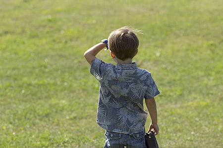 boy wearing gray and white floral short-sleeved shirt facing grass field thumbnail