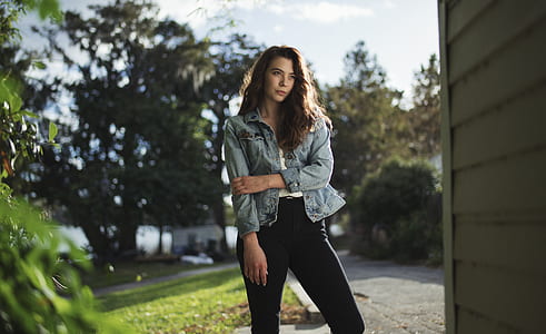 shallow focus photography of woman standing beside wall thumbnail