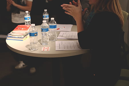 woman sitting near table with five drinking water bottles thumbnail