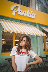 woman standing along white and yellow awning thumbnail