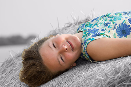 girl in white floral dress lying and haystock thumbnail