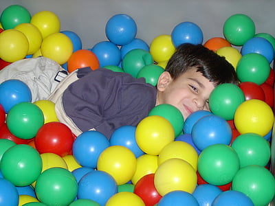 boy laying on play balls thumbnail
