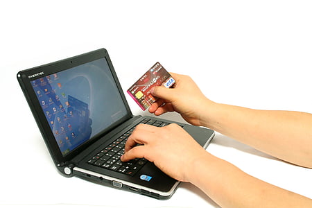 person holding credit card while using laptop thumbnail