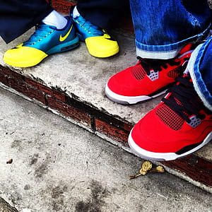 person wearing pair of red Air Jordan 4 shoes thumbnail