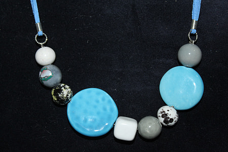 beaded teal, gray, and white pendant necklace on black surface thumbnail
