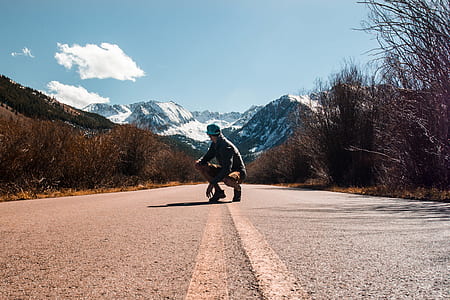 man sitting on road during daytime thumbnail