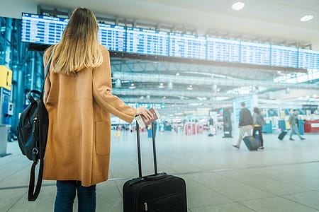 Young woman in coat with luggage at the airport thumbnail
