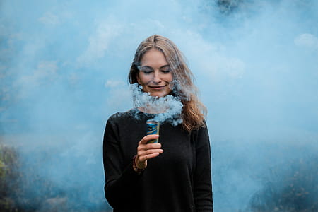 woman holding brown case with blue smoke powder thumbnail