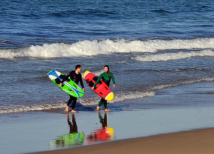 two person holding surfboards thumbnail
