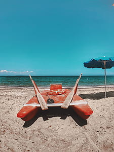 Photo of Red Watercraft on Seashore thumbnail