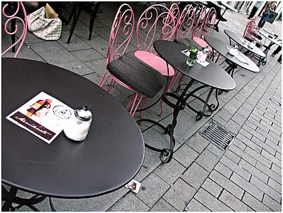 round black steel tables beside chairs on gray concrete brick ground thumbnail