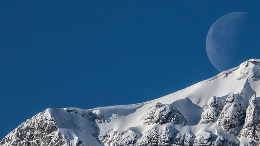 snow-capped mountain slope under full moon thumbnail