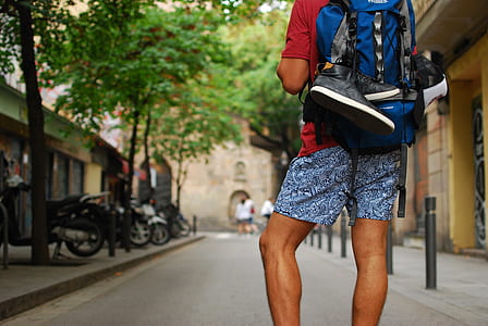 person with blue backpack standing on street at daytime thumbnail