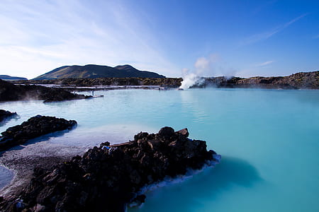 calm body of water between rock coastal photo thumbnail