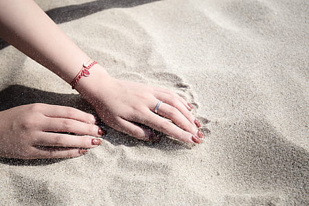 woman leaning both hands on brown sand thumbnail