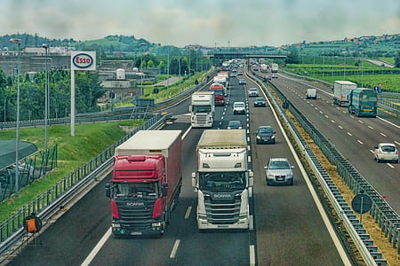 two white and red trucks running on road thumbnail
