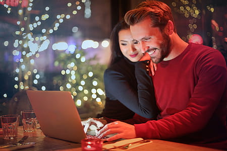 Young couple surfing on internet with laptop during romantic dinner in a restaurant thumbnail