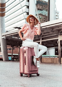 woman sitting on pink luggage bag thumbnail