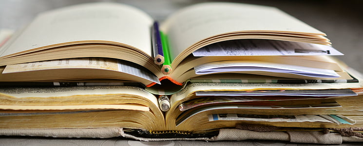 open books with pens stack thumbnail