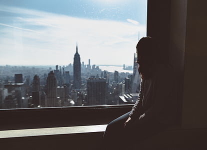 woman sitting beside clear glass window thumbnail