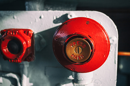 Close-up shot of a big red button, this image was captured on an old warship in Chatham Dockyard in Kent, England thumbnail
