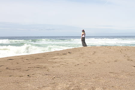 person standing beside ocean waves thumbnail