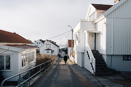 person waling near white wooden house thumbnail