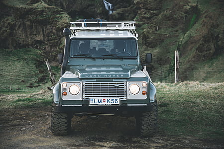 green Land Rover vehicle with license plate LM K56 park near cyclone fence during daytime thumbnail