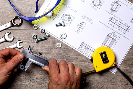 person holding black metal handheld tool in front of sketch paper thumbnail