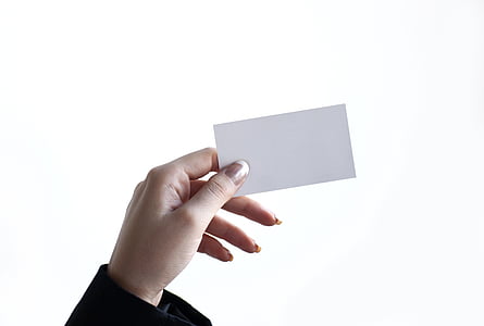 person's left hand holding white paper thumbnail
