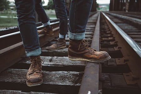 two people standing on railroad during day thumbnail