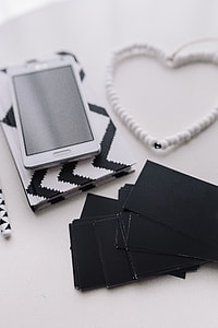 Black-and-white notebook and a white smartphone with various items thumbnail