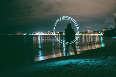 person standing near seashore holding white steel wool thumbnail