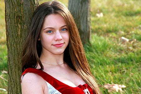 woman seating behind tree while smiling thumbnail