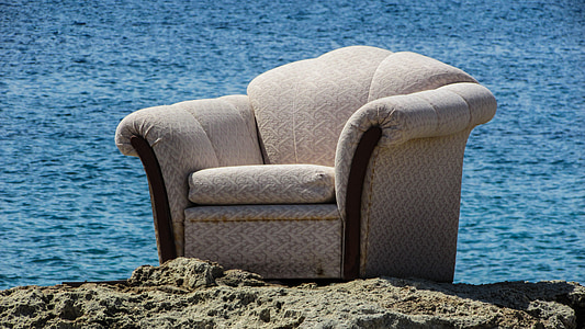white fabric armchair on rock thumbnail