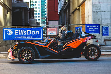 people riding orange and black Polaris Slingshot thumbnail