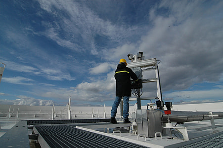 man working on industrial machine at rooftop thumbnail